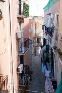 un callejón con ropa secándose en los tendederos entre edificios en Appartamenti San Marco, en Bari