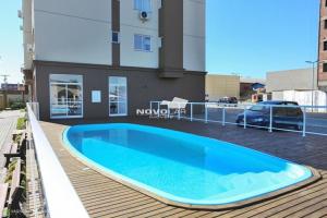 a large blue swimming pool on top of a building at Apartamento 2 quartos c/ Piscina 3 Ar-condicionado in Torres