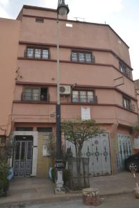 a pink building with a street light in front of it at Dar Benyounes in Benguerir