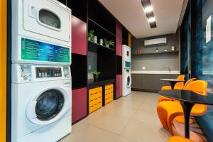 a laundry room with a washing machine and a table at Aurora Paulistana a passos do Metrô República in Sao Paulo