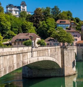 eine Steinbrücke über einen Fluss in einer Stadt in der Unterkunft Apartment Malti in Laufenburg