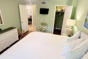 Un dormitorio con una gran cama blanca y una sala de estar. en A3 tile floors pet friendly easy access downstairs faces nice grassy area Close to pool, en Mallory Park 7 fotos más