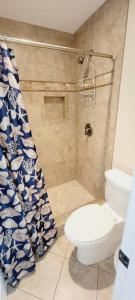 a bathroom with a toilet and a shower curtain at c2 Ocean Walk Pool view village area cozy Upstairs sleeps 5 1 king bed two sleepers in Mallory Park