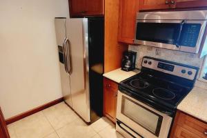 a kitchen with a stove and a refrigerator at c2 Ocean Walk Pool view village area cozy Upstairs sleeps 5 1 king bed two sleepers in Mallory Park