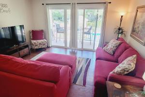 a living room with two red couches and a television at c2 Ocean Walk Pool view village area cozy Upstairs sleeps 5 1 king bed two sleepers in Mallory Park