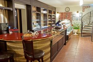 a bar in a restaurant with a counter and chairs at Pensiunea Luiza in Braşov