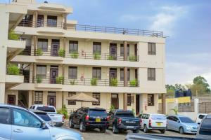 Walabi Mara Hotel في Narok: مبنى فيه سيارات تقف امامه