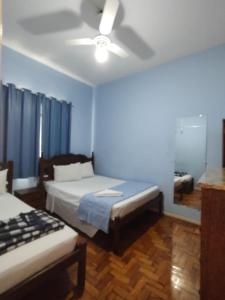 a bedroom with two beds and a ceiling fan at Hotel Mirante da Serra in Ouro Branco