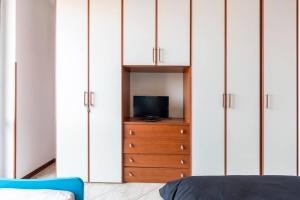a bedroom with white cabinets and a television on a dresser at Piacevole Appartamento Arzago in Arzago d'Adda