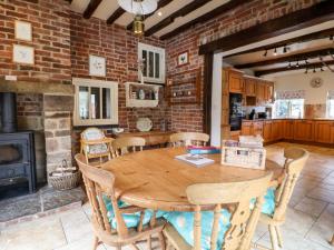 a wooden table in a kitchen with a brick wall at Mill Farm - The Farmhouse in Derby