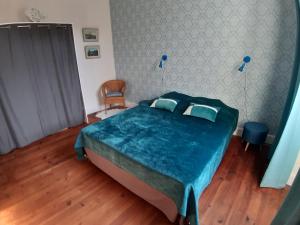 um quarto com uma cama grande e um cobertor azul em Villa MAGDA à 30 mn mer pour vacances ou cure em Dax