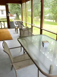 een glazen tafel en stoelen op een veranda bij Wagon Wheel Resort Lake Norfork in Gamaliel