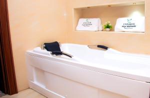 La salle de bains est pourvue d'une baignoire blanche et d'un miroir. dans l'établissement Modern Luxury Home W/ 24H Power Wi-Fi & Security, à Abuja