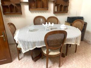 a dining room table with a white table cloth and chairs at Bayt Ateeq 2 Bethlehem بيت دار عتيق in Bethlehem