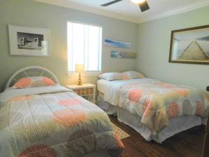 a bedroom with two beds and a window at Q4 Professionally decorated upstairs beautiful soothing colors close to back pool in Saint Simons Island +22 photos