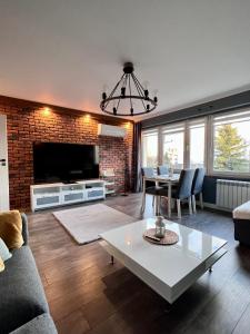 a living room with a couch and a table at Apartment of Love in Olecko