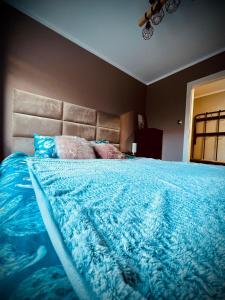 a bedroom with a large bed with a blue comforter at Apartment of Love in Olecko