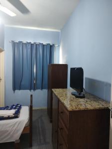 a room with a bed and a desk with a tv at Hotel Mirante da Serra in Ouro Branco