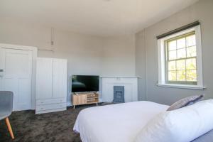 - une chambre blanche avec un lit et une télévision dans l'établissement Kepler View, à Warrnambool