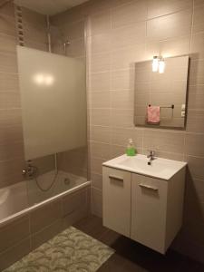 uma casa de banho com um lavatório, um chuveiro e uma banheira em Appartement Gauche avec balcon em Hargarten-aux-Mines