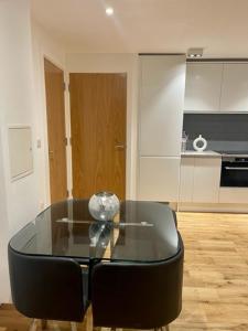 a glass table and a black chair in a kitchen at Monument Prime Location in the City of London in London