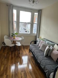 ein Wohnzimmer mit einem Sofa und einem Tisch in der Unterkunft apartment Lavender Hill in London