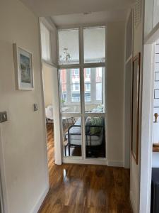ein Wohnzimmer mit einem großen Fenster und einem Tisch in der Unterkunft apartment Lavender Hill in London