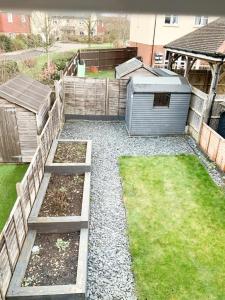un patio trasero con un jardín con césped y una valla en Barley House, en Andover