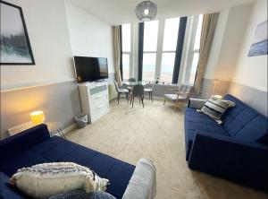 sala de estar con sofá azul y TV en 6 Burnett by Prestige Properties SA, en Seascale