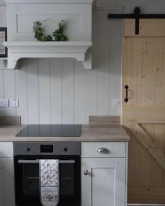 een keuken met een fornuis en een handdoek op de oven bij Stunning riverside cottage in central location in Donegal