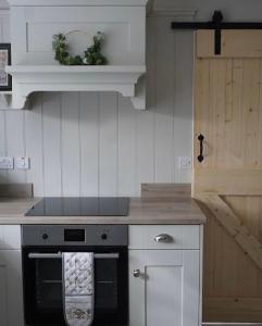 a kitchen with a stove with a towel on the oven at Stunning riverside cottage in central location in Donegal