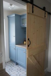 a door to a kitchen with blue cabinets at Stunning riverside cottage in central location in Donegal +64 photos