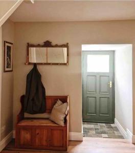 Habitación con puerta verde y banco con ventana en Stunning riverside cottage in central location en Donegal