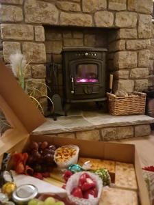 pudełko pełne jedzenia przed kamiennym kominkiem w obiekcie Stunning riverside cottage in central location w mieście Donegal
