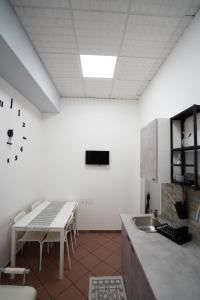 uma cozinha com uma mesa e um lavatório em AYN Apartment em Tiriolo