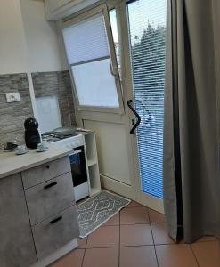 uma cozinha com um fogão, uma janela e uma porta em AYN Apartment em Tiriolo