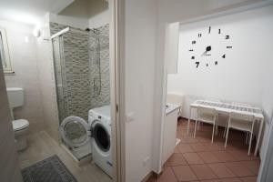 uma casa de banho com uma máquina de lavar roupa e uma mesa com cadeiras em AYN Apartment em Tiriolo