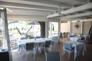 uma sala de jantar com mesas e cadeiras brancas em HOTEL VULCI em Montalto di Castro