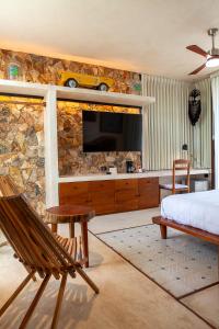 a bedroom with a bed and a tv on a stone wall at La Parcela Cunkal in Conkal