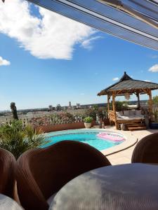 eine Terrasse mit einem Pool und einem Pavillon in der Unterkunft Les Collines d'Ugernum in Beaucaire