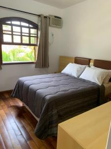 a bedroom with a large bed with a window at Pousada da Seresta in Diamantina