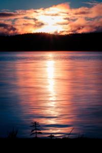 a sunset over a body of water at Pimishka Chalet-Cottage-Studios in Bouchette