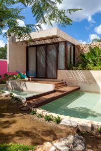 une maison avec une piscine et une terrasse en bois dans l'établissement La Parcela Cunkal, à Conkal