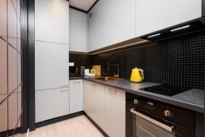 kuchnia z białymi szafkami i żółtym czajnikiem na ladzie w obiekcie Salomea apartments Kraków, Stary Kazimierz, Tauron arena w Krakowie +14 zdjęć