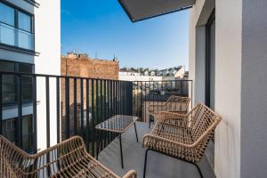 trzy krzesła i stół na balkonie w obiekcie Salomea apartments Kraków, Stary Kazimierz, Tauron arena w Krakowie