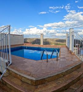 a swimming pool with a wooden deck and a fence at Pousada da Seresta in Diamantina