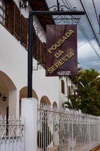 a sign for a house with a white fence at Pousada da Seresta in Diamantina