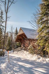 uma cabana de madeira na neve com uma estrada em RCNT Chalets Mont-Tremblant em Lac-Superieur