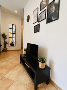 una sala de estar con una mesa negra y cuadros en la pared en Corso Home- central apartment in Menton, en Menton