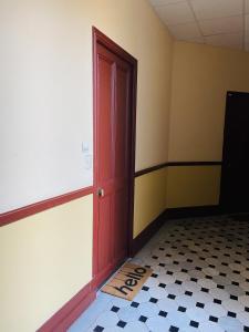um quarto vazio com uma porta vermelha e um piso xadrez em Corso Home- central apartment in Menton em Menton